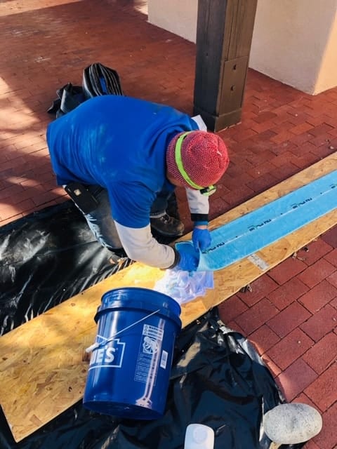 CaitCo employee in a red beanie prepping to do a Trenchless Sewer Line Repair.